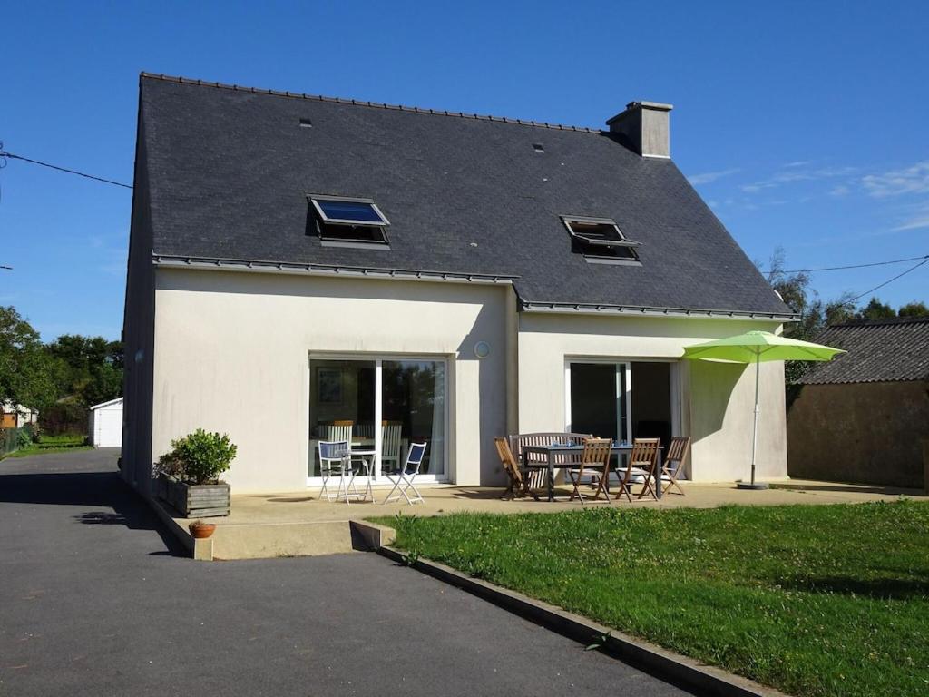 een huis met een patio met een tafel en stoelen bij Holiday home, Moëlan sur Mer in Moëlan-sur-Mer