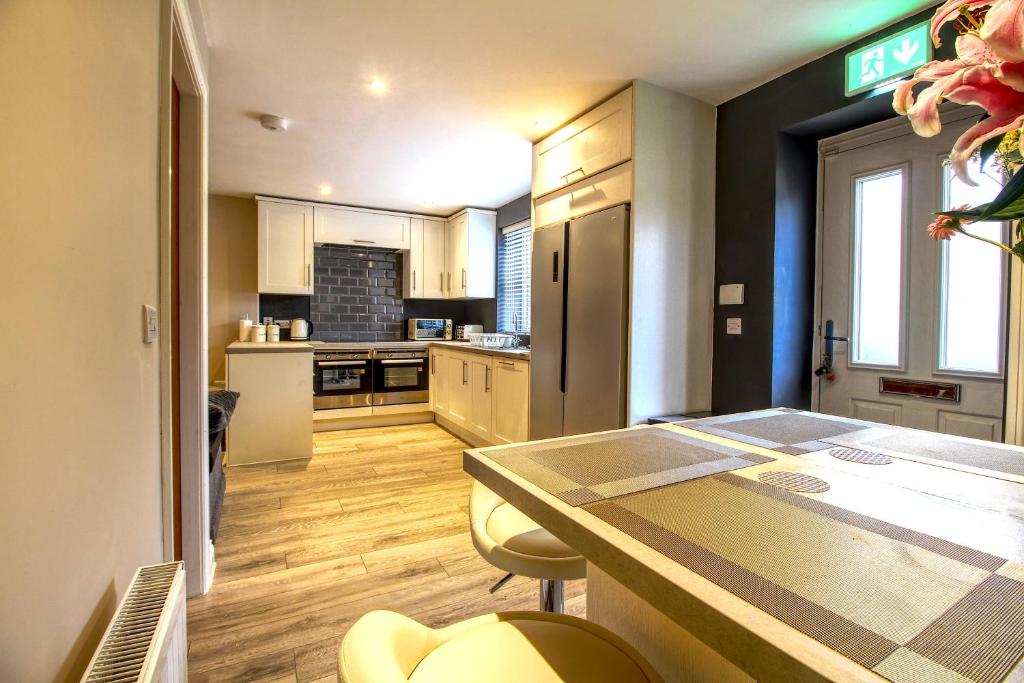 a kitchen with a table and chairs in a room at Central Huddersfield House, inc parking in Huddersfield