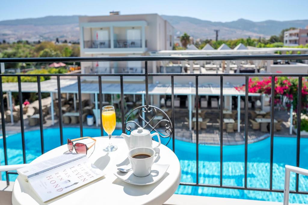 ein Tisch mit einer Tasse Kaffee und einem Glas Orangensaft in der Unterkunft Peridis Family Resort in Kos-Stadt