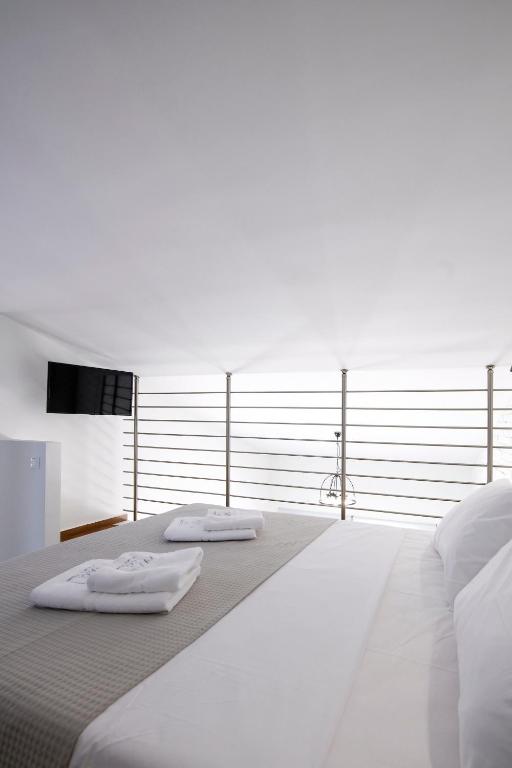 a white bed with two towels on top of it at AG Luxury Villas, Iraklitsa in Iraklitsa