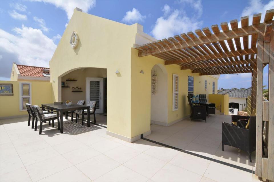 a patio with a table and chairs and a pergola at Penthouse Prikichi D2 in Kralendijk