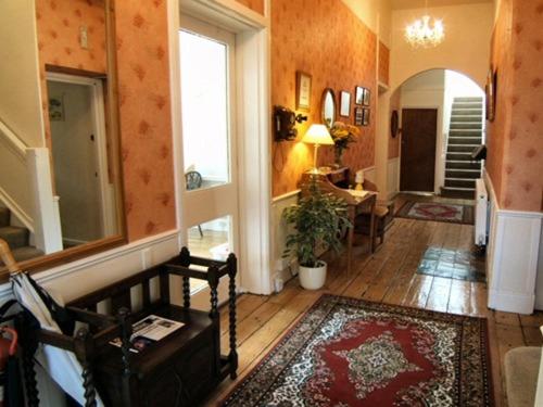 a living room with a hallway with a table and a mirror at Cornerways in Ventnor