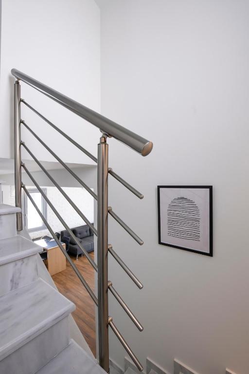 a staircase with a metal rail and a picture on the wall at AG Luxury Villas, Iraklitsa in Iraklitsa