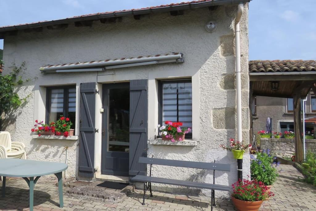 una pequeña casa con una puerta azul y una mesa en Les Souchottes, charmante maisonnette en Bulligny