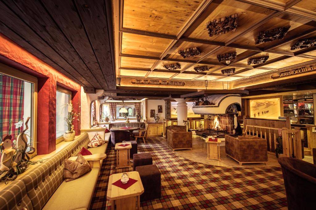 a living room with couches and chairs in a building at Hotel Neuhintertux in Tux