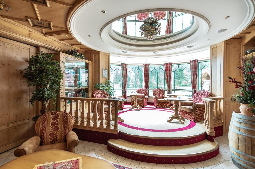 a lobby with a table and chairs and a large window at Hotel Neuhintertux in Tux