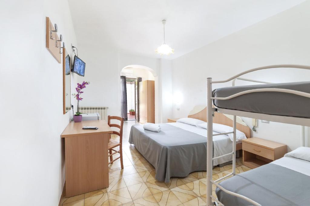 sypialnia z 2 łóżkami, biurkiem i łóżkiem piętrowym w obiekcie Casa Cigliano w mieście Ischia
