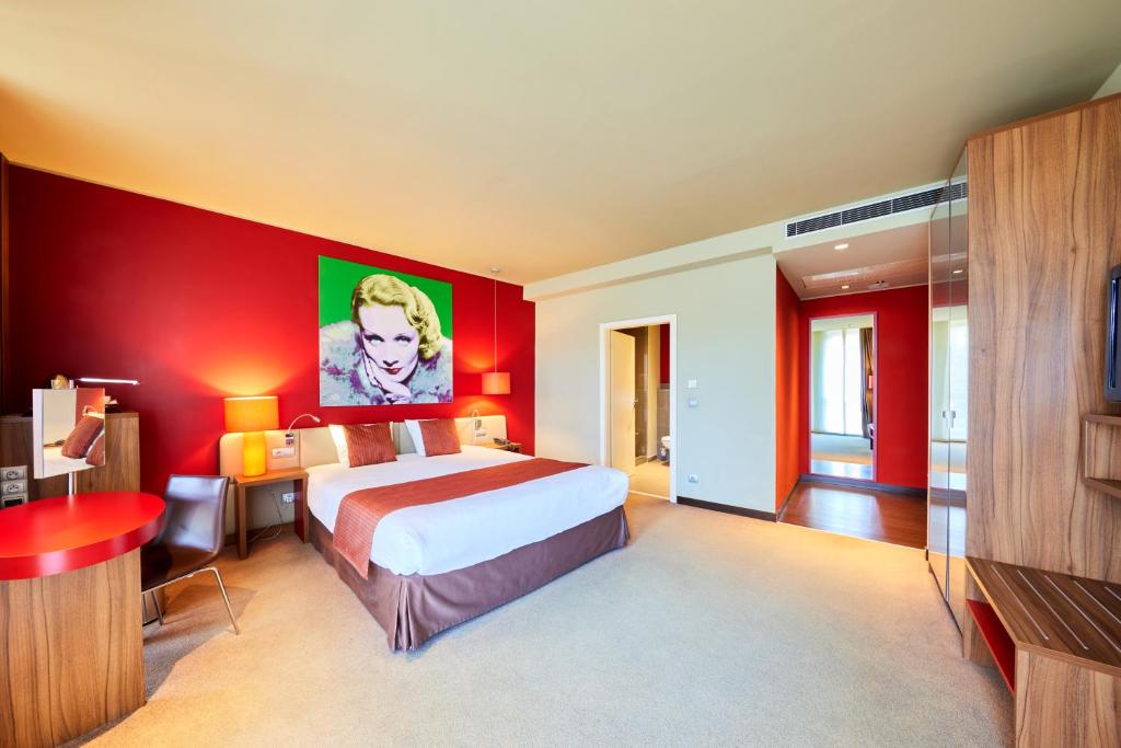a bedroom with a bed and a red wall at Clarion Congress Hotel Bratislava in Bratislava
