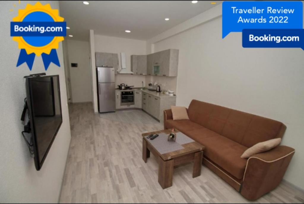 sala de estar con sofá y TV y cocina en Host Net Iverieli, en Tiflis