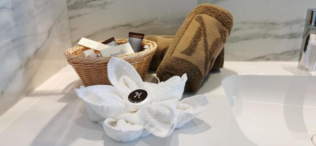 a basket of towels and shoes on a bathroom counter at Hotel Neuhintertux in Tux