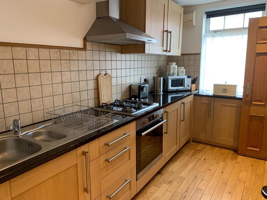 a kitchen with a sink and a stove top oven at The Cottage At The Retreat in Leek