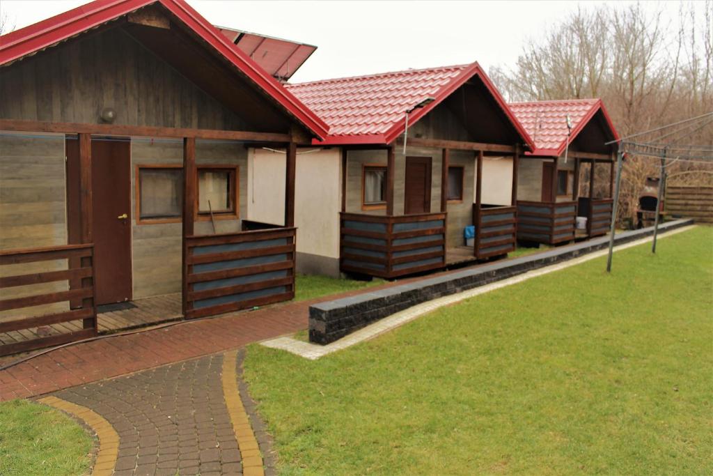 una fila de cabañas con techos rojos en Camping domki letniskowe, en Varsovia