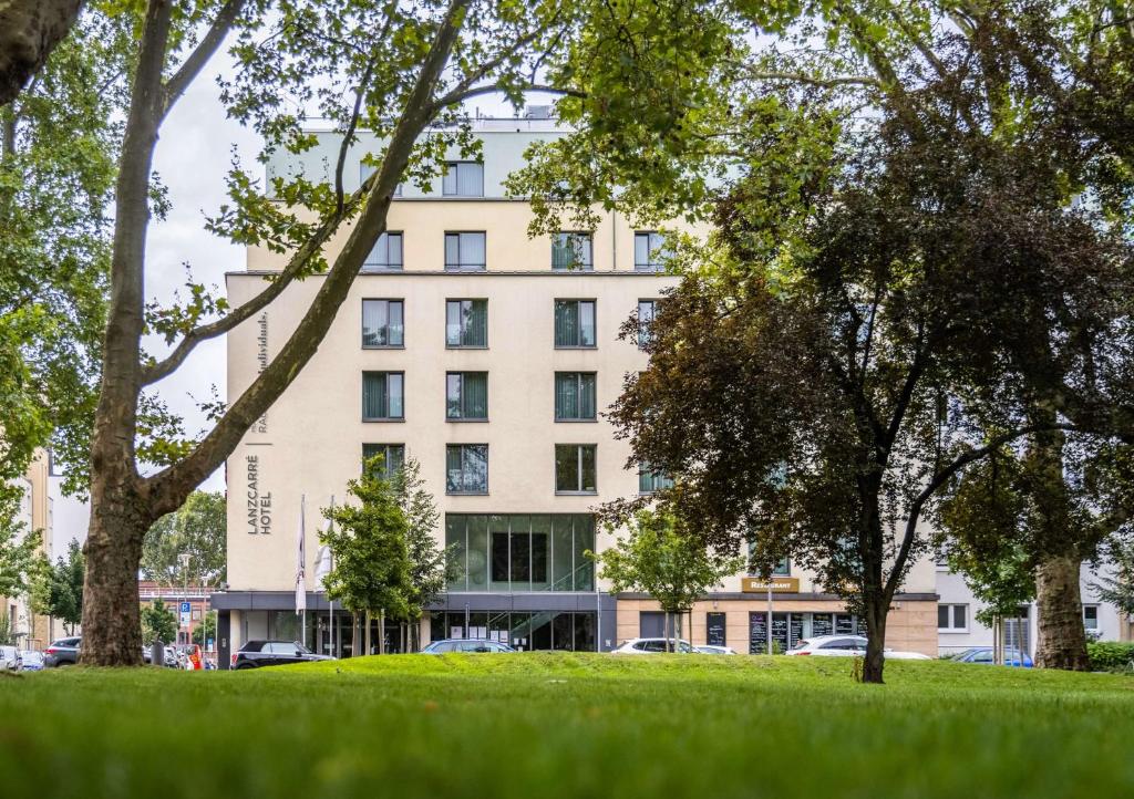 ein Gebäude mit Bäumen davor in der Unterkunft Lanzcarré Hotel Mannheim, a member of Radisson Individuals in Mannheim
