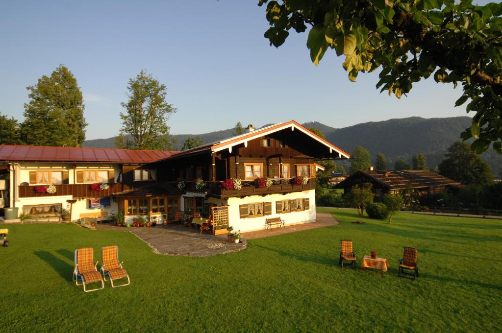 ein großes Haus mit Stühlen im Hof in der Unterkunft Ferienwohnung Grünsteineck in Schönau am Königssee