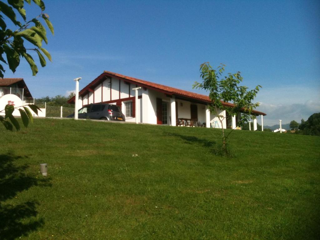una casa en una colina con un campo verde en Etxettipia, en Itxassou