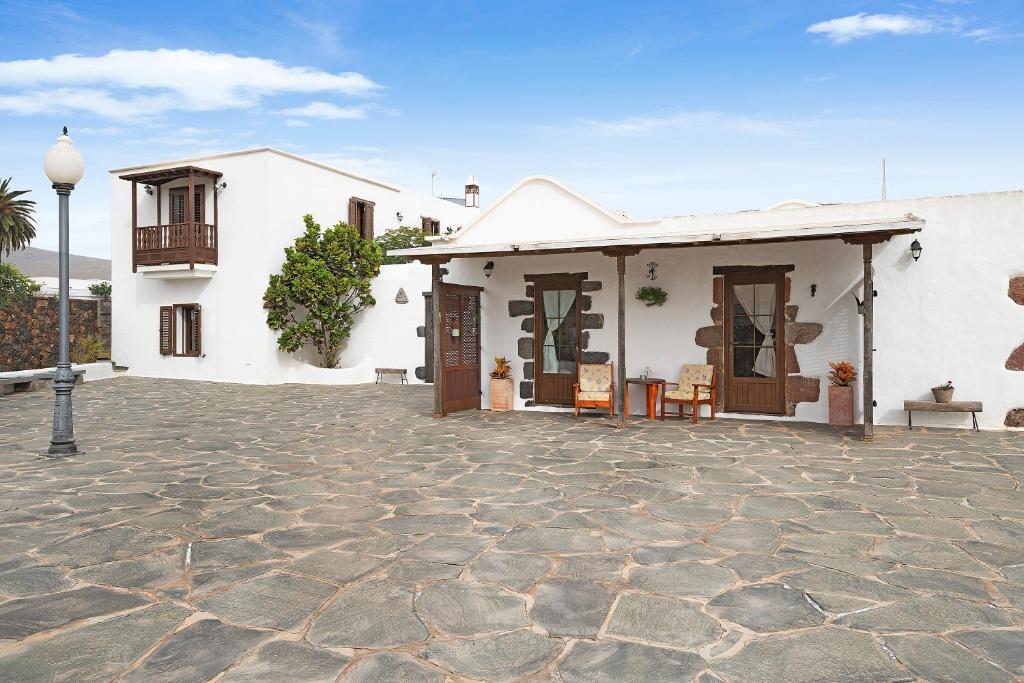 een wit huis met een patio ervoor bij La Escuelita in Los Valles
