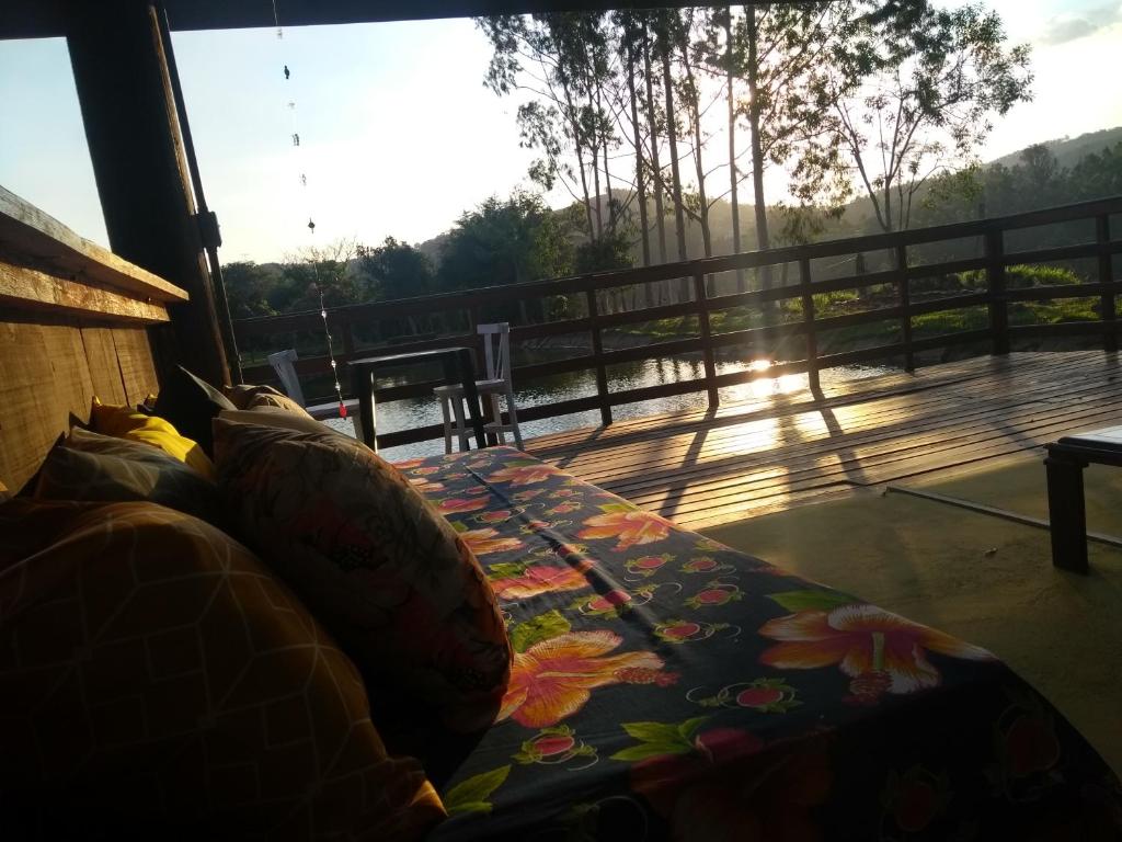 a couch with pillows on a balcony with a view at Pousada Erva Doce in Monte Alegre do Sul