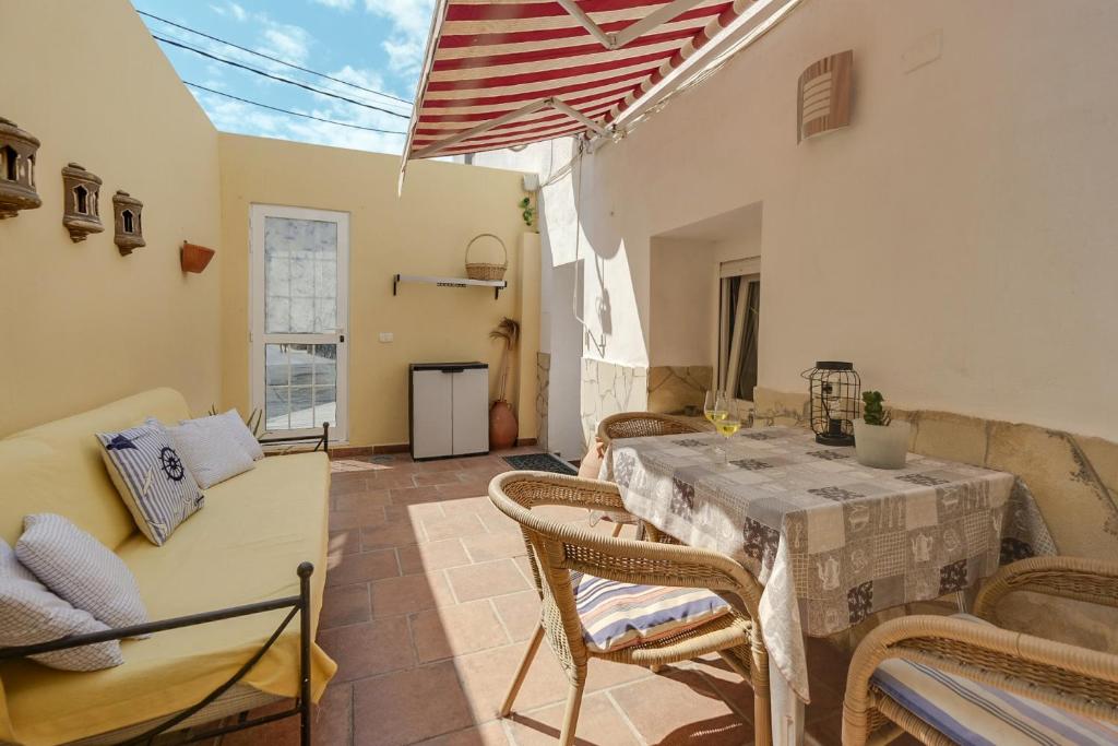 a patio with a table and chairs in a room at Apartamento Planta Baja in Los Abrigos