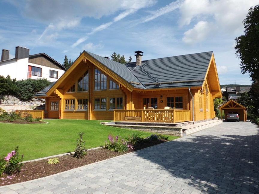 a large wooden house with a gambrel roof at Vakantiehuis Luxe BlokhuisA in Willingen