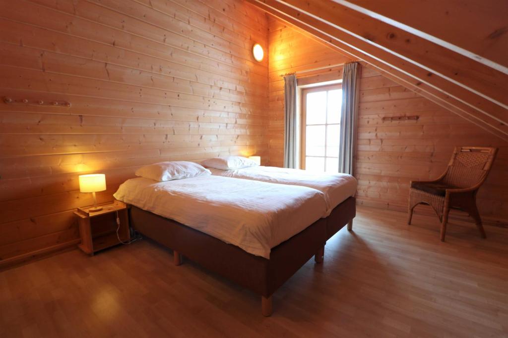 a bedroom with a bed in a wooden wall at Luxus Blockhaus Willingen Sonnenhang Lodge A in Willingen