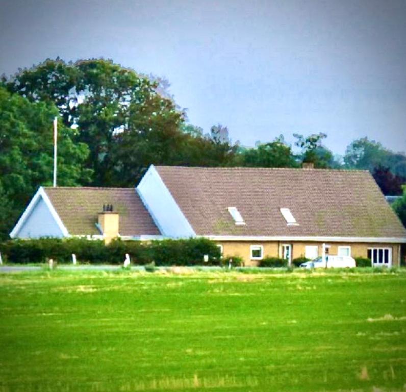 een groot huis met een groen veld ervoor bij Skorstensfejerens Bed & Breakfast in Bogense