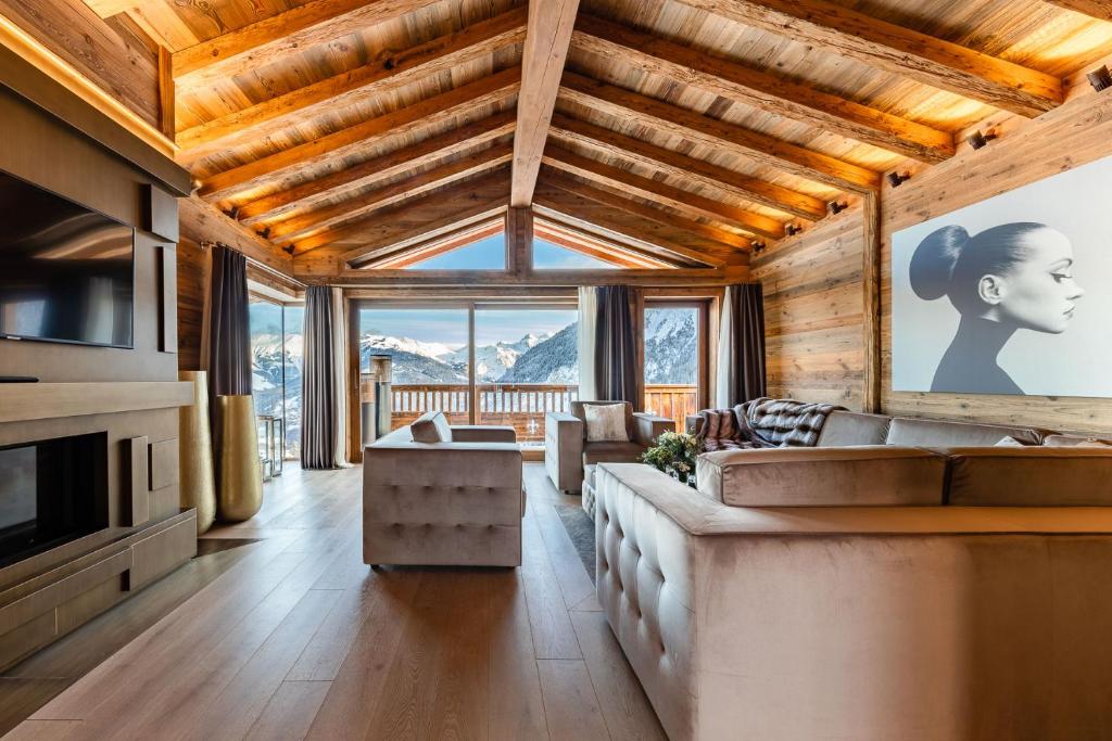 a living room with a large couch and a table at Ultima Courchevel Belvédère in Courchevel