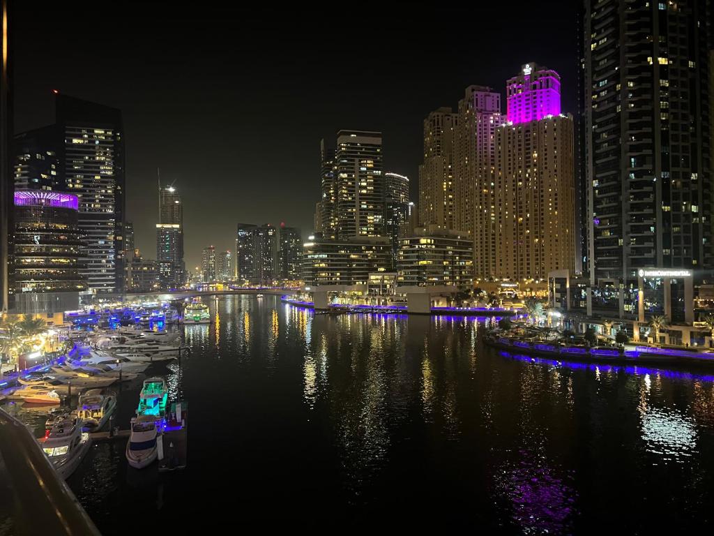 a city skyline at night with boats in the water at Amazing View I 1min Walk to Marina Mall I Close to Beach in Dubai