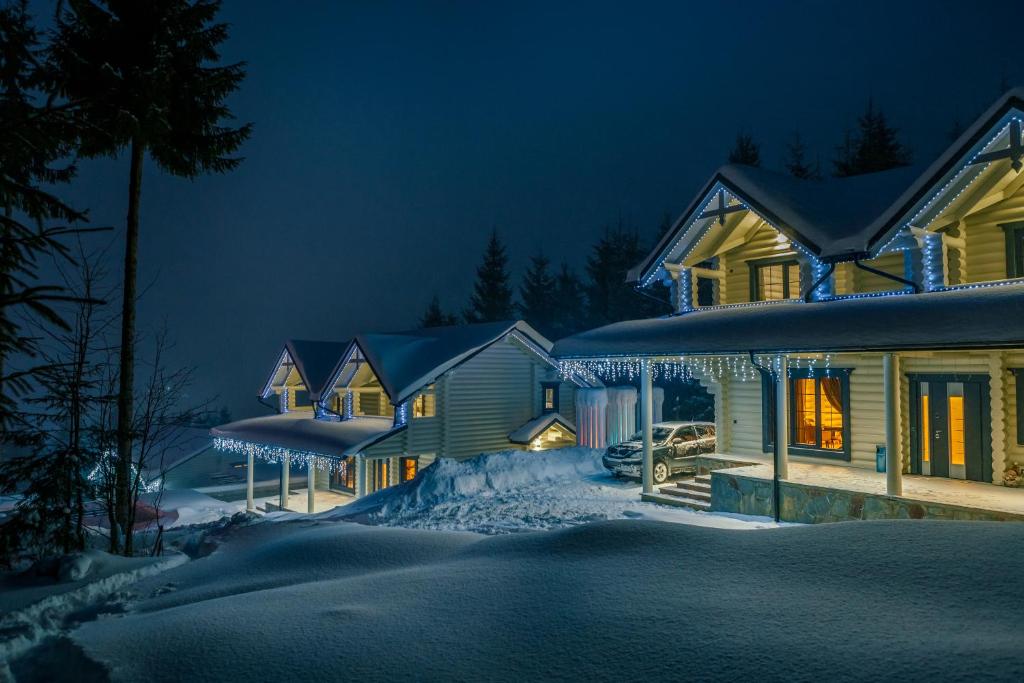 a house covered in snow at night at WhiteWood Cottages in Bukovel