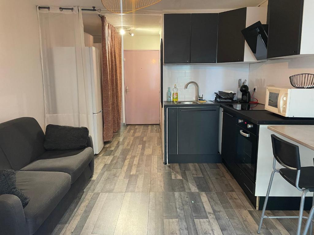 ein Wohnzimmer mit einem Sofa und einer Küche in der Unterkunft Les Oliviers in Balaruc-les-Bains