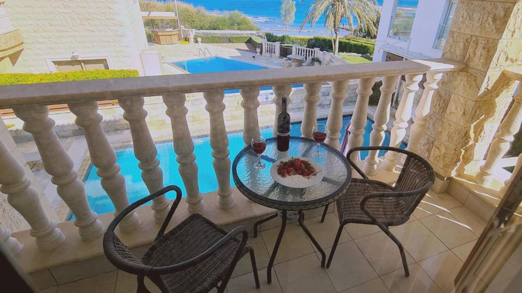 stół i krzesła na balkonie z basenem w obiekcie STAY Ocean View Villa w mieście Paralimni