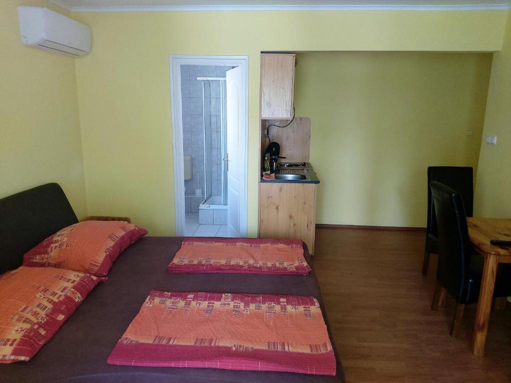 A bed or beds in a room at Ilona Apartmanház