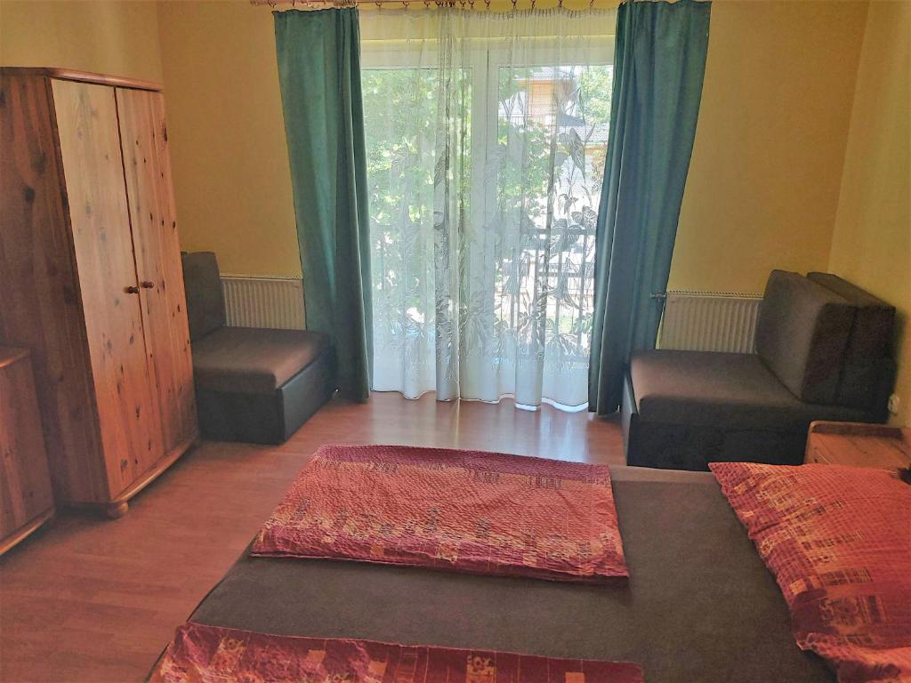 A bed or beds in a room at Ilona Apartmanház