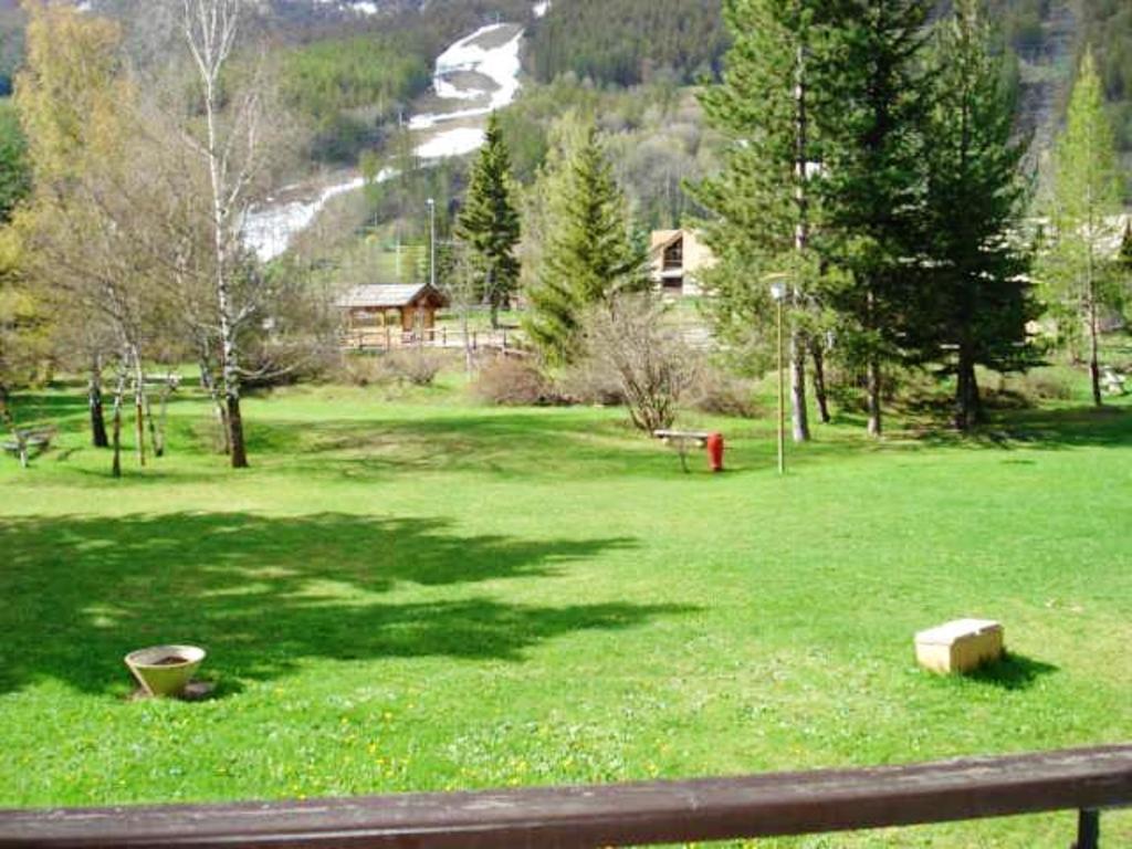 a field of green grass with a red fire hydrant at Appartement d'une chambre avec jardin clos et wifi a La Salle les Alpes in La Salle Les Alpes