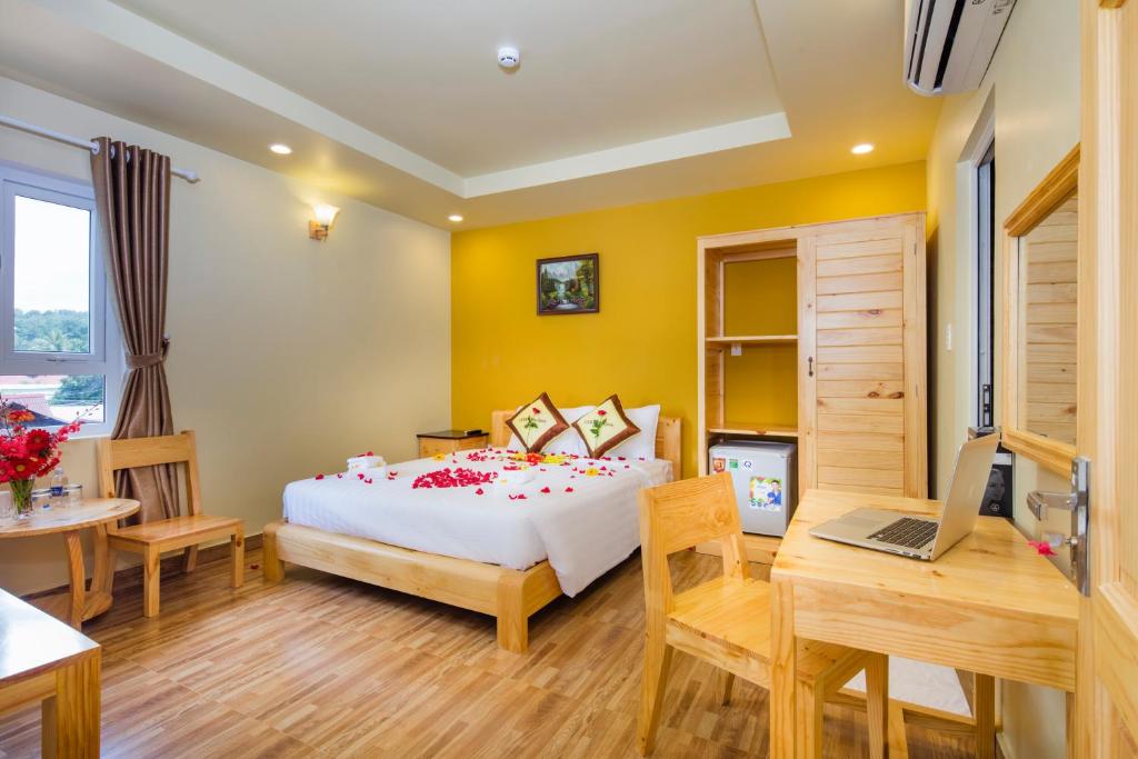 a bedroom with a bed and a desk and a laptop at Lucky Phu Quoc Hotel in Phú Quốc