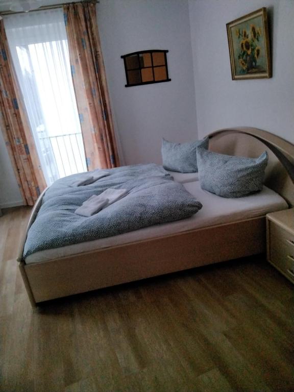 Bett in einem Schlafzimmer mit Holzboden in der Unterkunft Pension Insulaner in Bremen