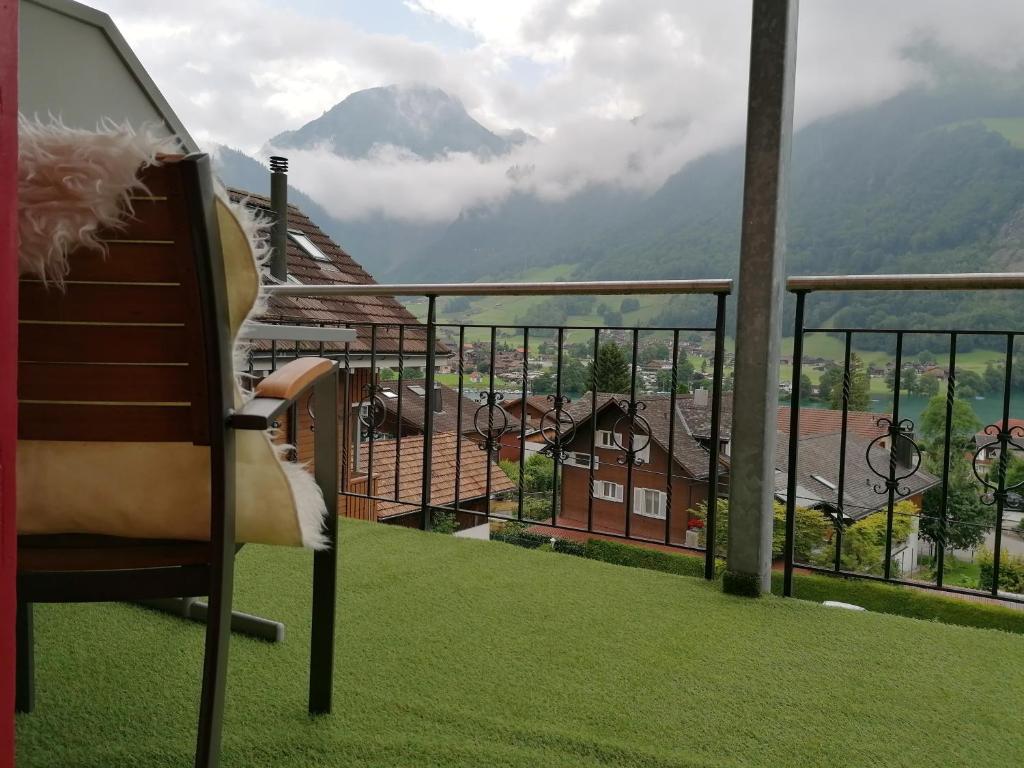 a chair on a balcony with a view of a mountain at Elliotts Bed & Bar in Lungern