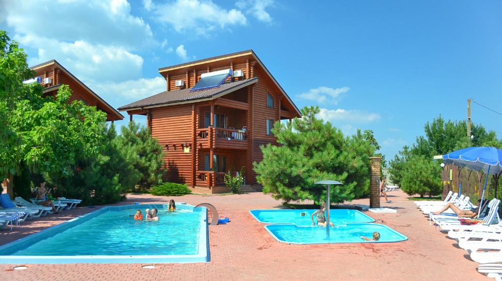 un resort con due piscine con persone di Парк-отель Коттеджи Меркурий a Hrybivka