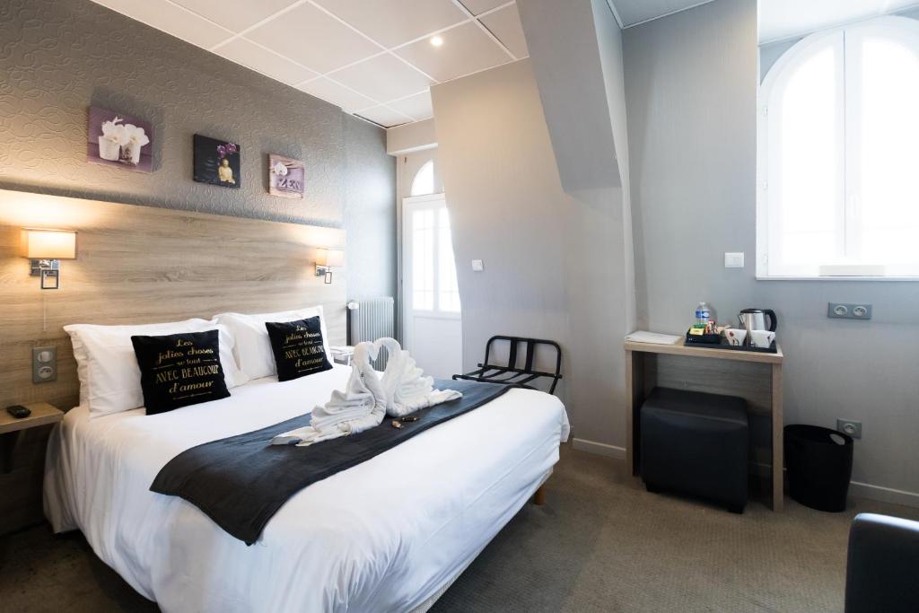 een hotelkamer met een groot wit bed erin bij Hotel de la Terrasse in Berck-sur-Mer