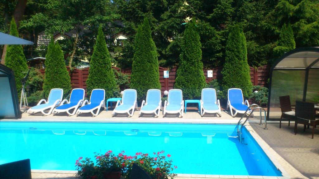 a group of chairs and a swimming pool at Pensjonat Perła in Pobierowo