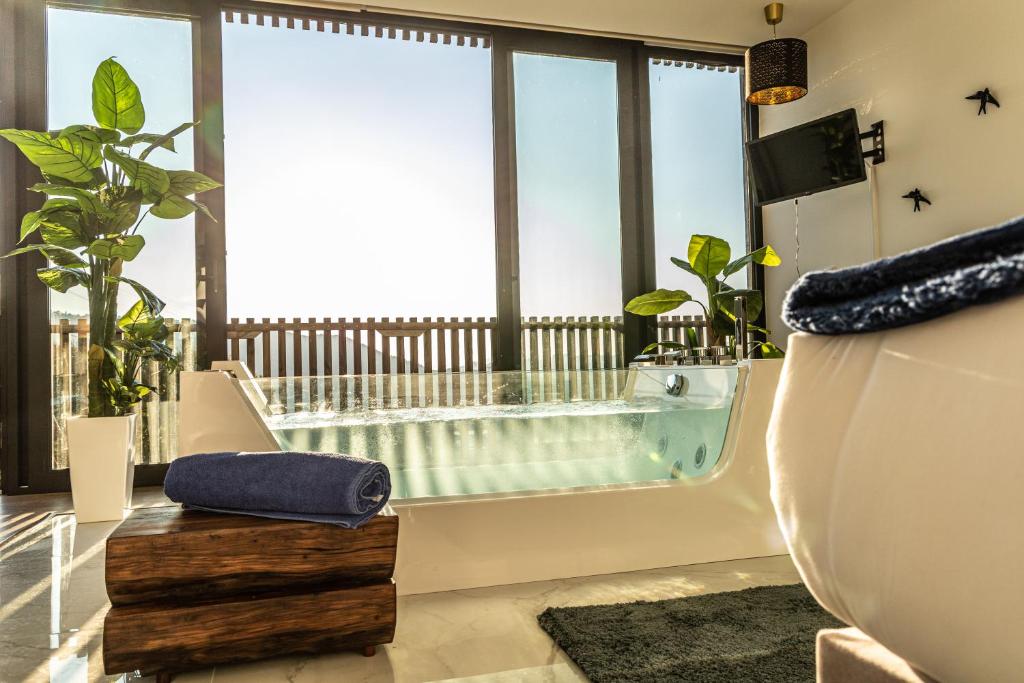uma casa de banho com banheira e uma grande janela em Peso Village em Amarante