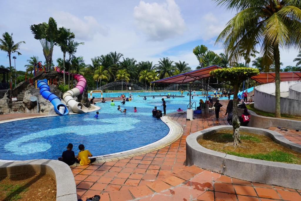 a large swimming pool with people playing in it at Bukit Beruntung Resort in Rawang