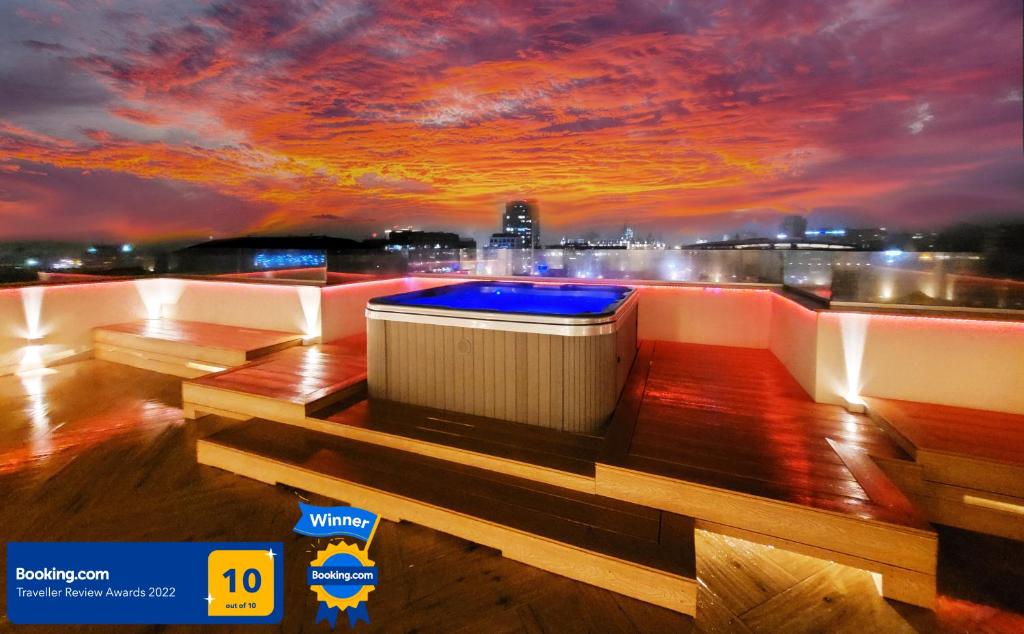 Terrace Suites Iasi في ياش: حوض استحمام ساخن على سطح مبنى مع غروب الشمس