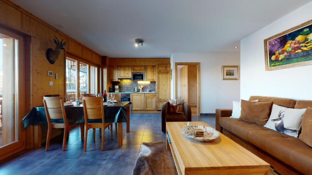 a living room with a couch and a table at Hauts de Veysonnaz SAUNA & VIEW apartments in Veysonnaz