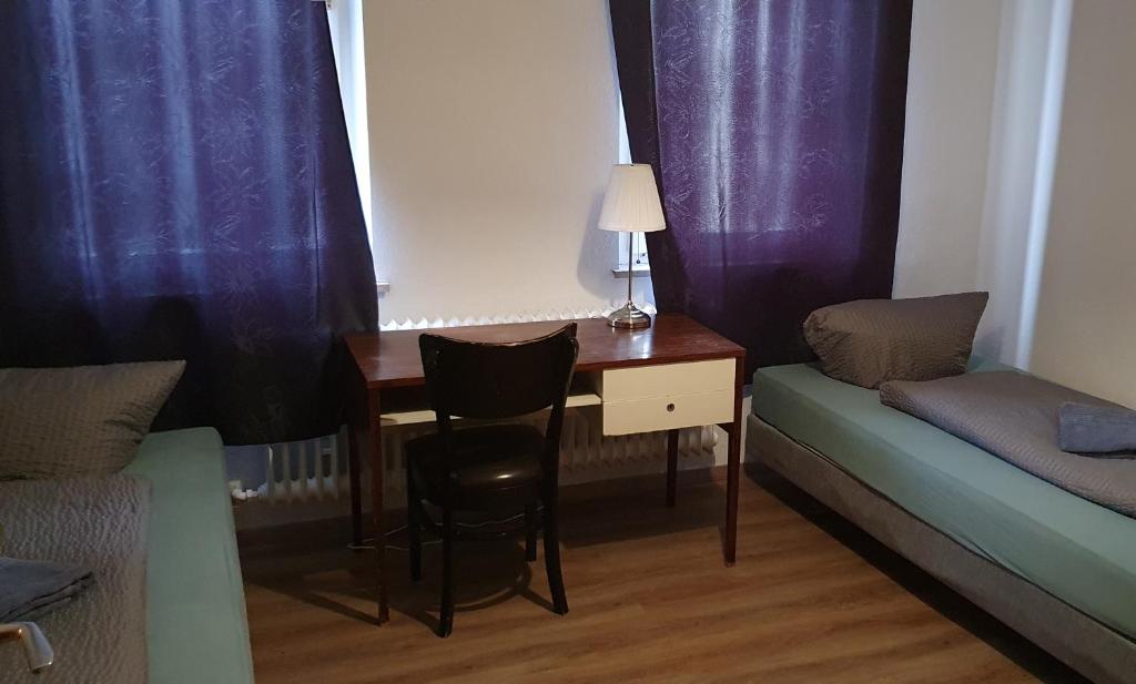 Zimmer mit einem Schreibtisch, einem Bett und einem Tisch in der Unterkunft Hotel Berkut in Fürth