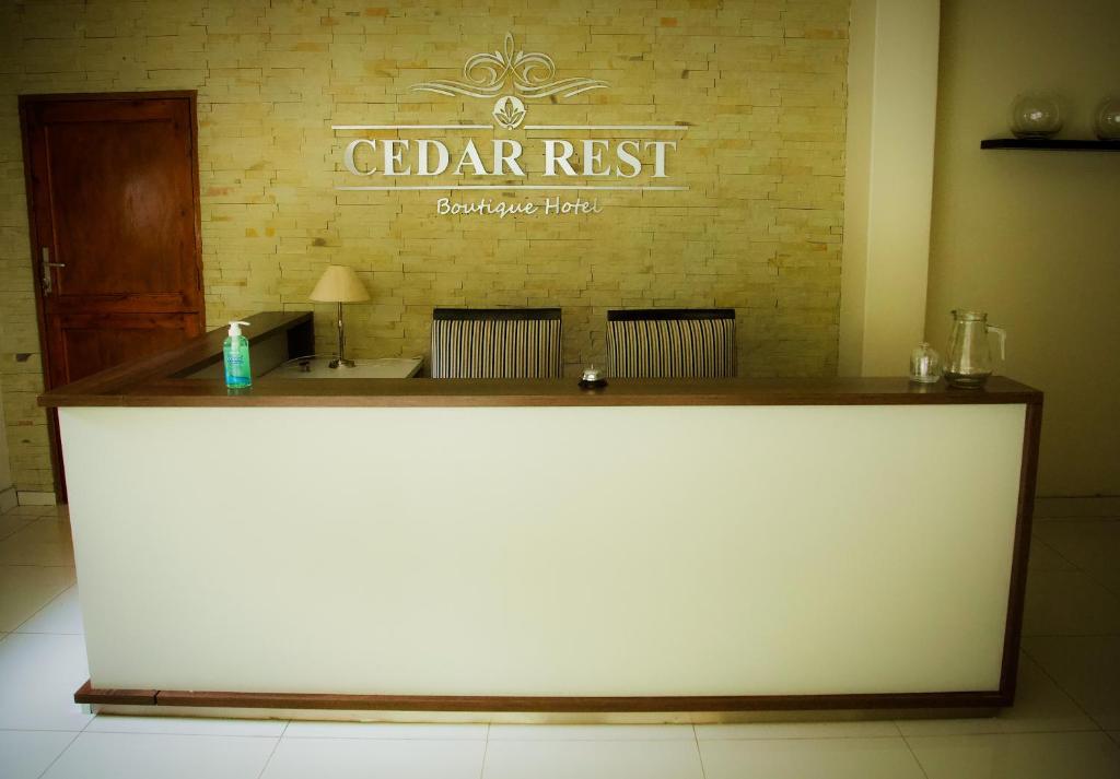 Cedar Rest Boutique Hotel في Chartwell: مكتب استقبال مع علامة على جدار من الطوب