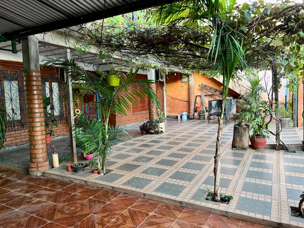 un patio con palmeras y un edificio de ladrillo en Apart Nicolas en Puerto Iguazú