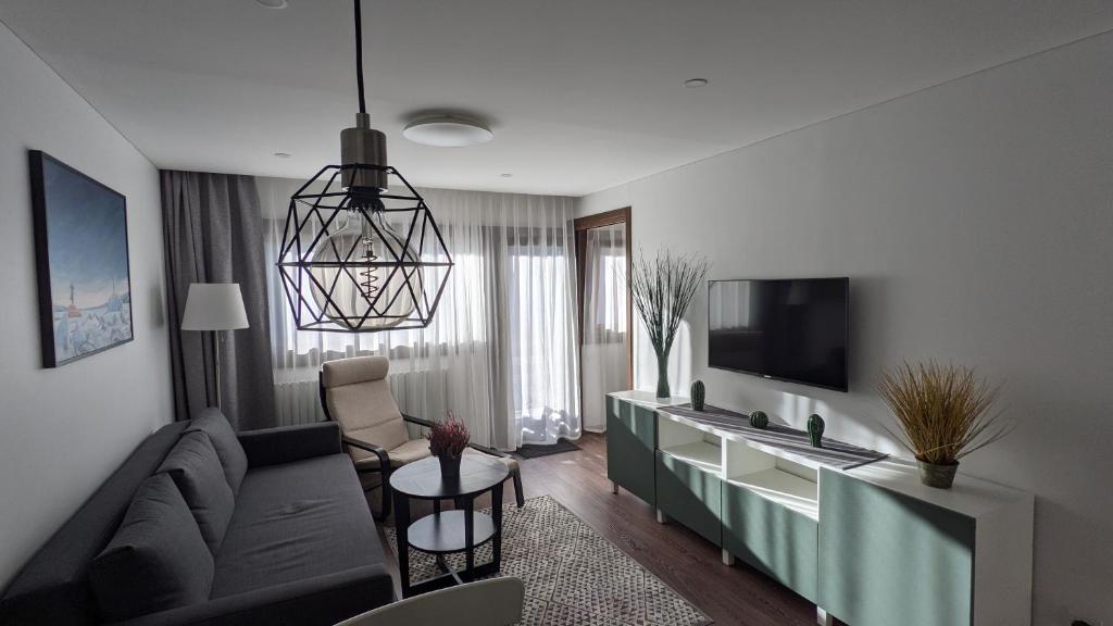 ein Wohnzimmer mit einem Sofa und einem TV in der Unterkunft Cervinia Apartment 2121 - Ski & Mountain Panorama in Breuil-Cervinia