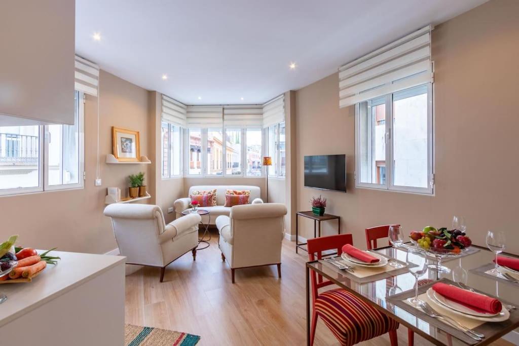 a living room with a table and chairs at Plaza Nueva Deluxe Suite by Valcambre in Seville