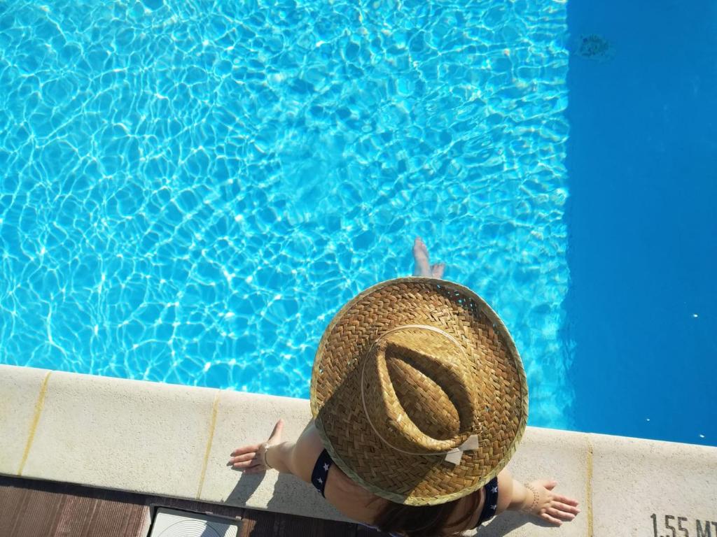 uma pessoa usando um chapéu de palha em uma piscina em Hotel Boavista - Vintage House em Monfortinho