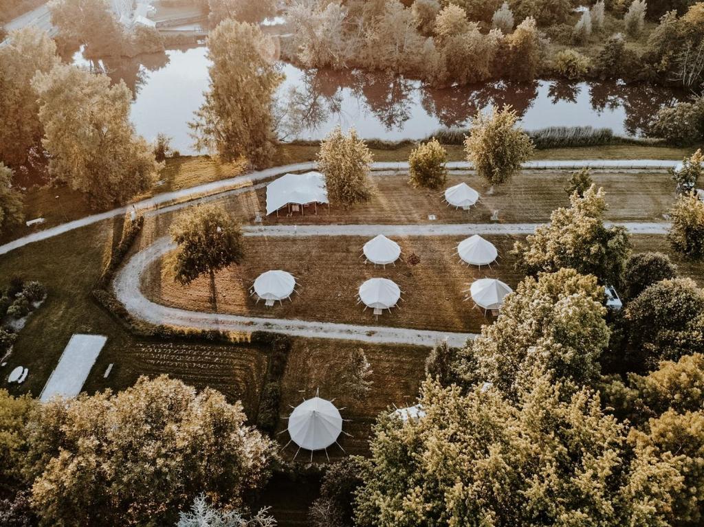 - une vue aérienne sur un jardin avec des parasols dans l'établissement Lodg'ing Nature Camp Châteaux de la Loire, à Cellettes